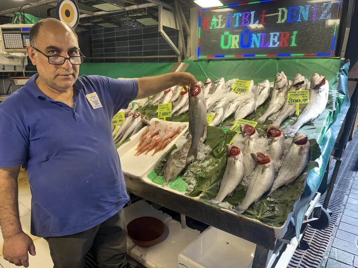 Fishmonger presenting the day's fresh catch at Kadıköy fish market, Istanbul — where lakerda and çiroz begin