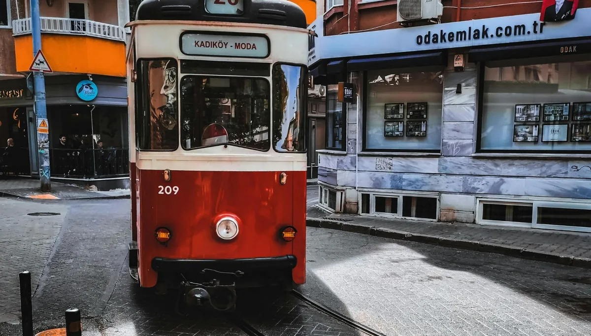 The historic Moda tram passing rain-slicked streets on an evening in Kadıköy, Istanbul