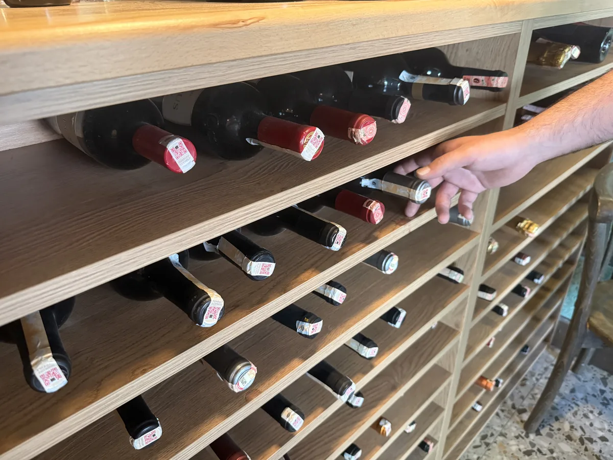 Choosing a bottle of native-grape Turkish wine from the wine wall at WAYANA Wine Bar in Moda, Kadıköy